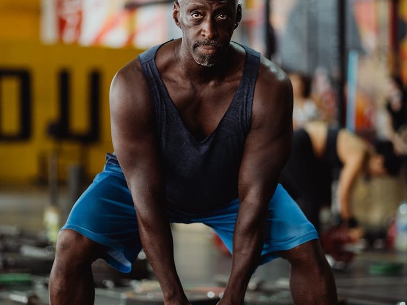 Man holding a kettlebell with proper form, focused expression.